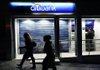 A customer uses a Citibank ATM at a branch bank in Athens, Greece, in November. Citigroup is one of several banks warning shareholders and customers about Internet attacks. 