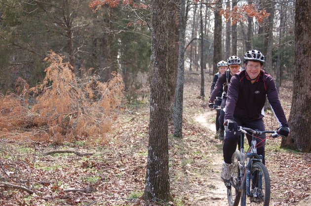 from-the-front-steve-lercher-who-developed-the-lercher-15-trails-in-mcrae-rides-mountain-bikes-with-jason-morgan-and-tanya-lercher-steves-wife-along-one-of-the-trails-on-steves-familys-property