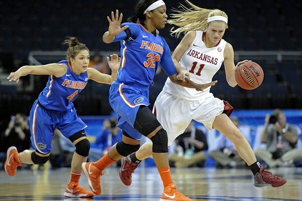 Arkansas guard Calli Berna (11) tries to get around the defense of Florida forward Jennifer George (32) during the first half of an NCAA college basketball game at the Southeastern Conference tournament, on Thursday, March 7, 2013, in Duluth, Ga. (AP Photo/John Amis)