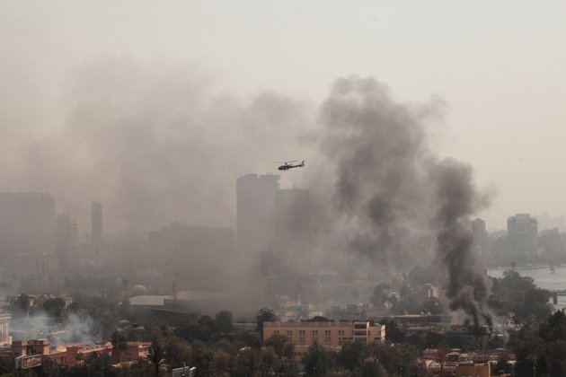 smoke-rises-from-the-police-officers-club-left-and-the-egyptian-soccer-federation-right-as-a-police-helicopter-surveys-the-scene-after-protesters-set-fire-following-a-court-verdict-in-saturday-march-9-2013-fans-of-cairos-al-ahly-club-have-stormed-egypts-soccer-federation-headquarters-set-it-ablaze-after-a-court-acquitted-seven-of-nine-police-official-on-trial-for-their-alleged-part-in-deadly-stadium-melee-a-fire-also-broke-out-saturday-in-a-nearby-police-club-but-it-was-not-immediately-known-whether-al-ahly-fans-started-the-blaze-there-too
