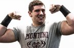 Defensive lineman Dylan Thompson flexes after flipping a 750 pound tire three times. 