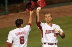 Arkansas batter Isaac Hellbusch is greeted at home plate by teammate Willie Schwanke after hitting a two-run home run in the fourth inning in Tuesday night's game against Alabama A&M at Baum Stadium in Fayetteville.