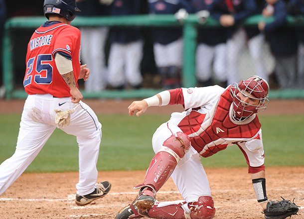 ole-miss-third-baseman-andrew-mistone-scores-as-arkansas-catcher-jake-wise-loses-the-throw-from-the-field-sunday-march-17-2013-during-the-fourth-inning-of-play-against-arkansas-at-baum-stadium