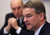 Andy Allison (front), Medicaid director for the state Department of Human Services, and John Selig, the department’s director, answer questions Monday during a news conference about the revised cost and savings projections of Medicaid expansion. 