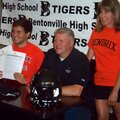 Dillon Wade, left, smiles moments after the Bentonville senior signed his football letter of intent ...