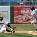 Naturals shortstop Orlando Calixte, left, falls as he misplays a throw as Tulsa center fielder Rafae...