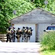 Members of the Benton County Sheriff's Office SWAT team, on May 14, approach a house to search for a shooting suspect, who was later identified as also being the shooting victim.