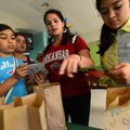 Fifth-grade teacher Sarah Cassady, center, gives Natalie Martinez, 11, Angelita Fuentes, 11, and Mel...
