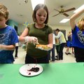 Zach McCoy, 11, left, Maeve Smith, 10, and Jacinda Montgomery, 11, work an assembly line Wednesday m...