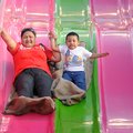 Monica Debrum, left, holds hands Friday with Ethan Debrum, 4, as they speed down a giant slide at th...