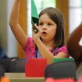 Amelia Sage, 8, above, inspects her folds Wednesday while making a paper crane at the Bentonville Pu...