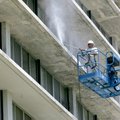 Val Graves with Heartland Painting of Rogers works on a lift Friday as he washes the south side of R...