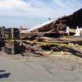 Officials discuss the damage at the Bicycle Doctor in Benton. A truck hauling a load of logs crashed...