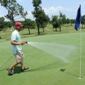 Aaron Curry, assistant superintendent of Springdale Country Club, waters the No. 2 green Friday duri...