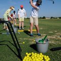 Baylee Maes, right, practices her swing Tuesday at First Tee golf center in Lowell. 