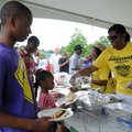 David Wright, 14, left, helps his sister Karyssa Wright, 5, get a hamburger from Charisa Burkhead, r...