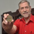 Weaver shows a commemorative coin he received following the completion of proton therapy. 