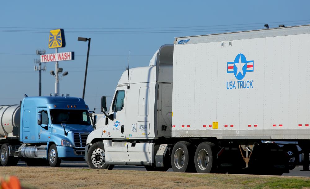 A USA Truck tractortrailer idles in a parking area at 