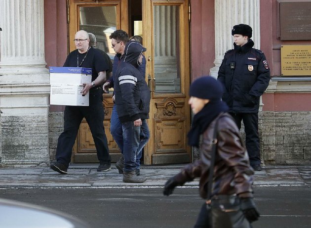 a-man-carries-boxes-from-the-us-consulate-in-st-petersburg-russia-as-a-russian-police-officer-guards-the-entrance-friday