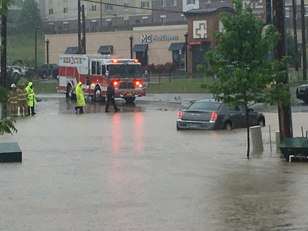 Emergency vehicles block the roadway around a stalled vehicle during flooding on Central Avenue in the Franklin Street area. Photography by Corbet Deary of The Sentinel-Record.